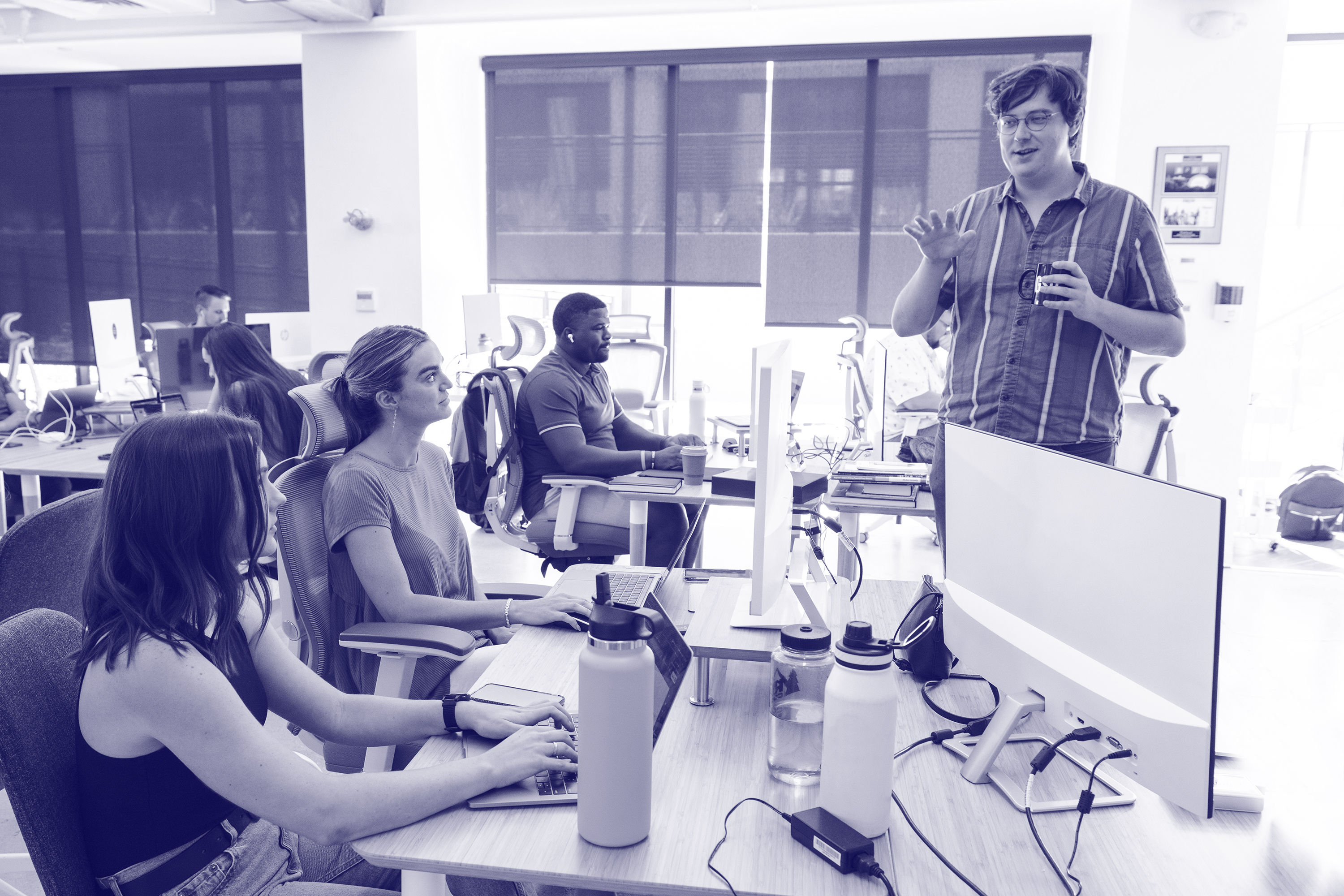 A group of people speaking in an office.