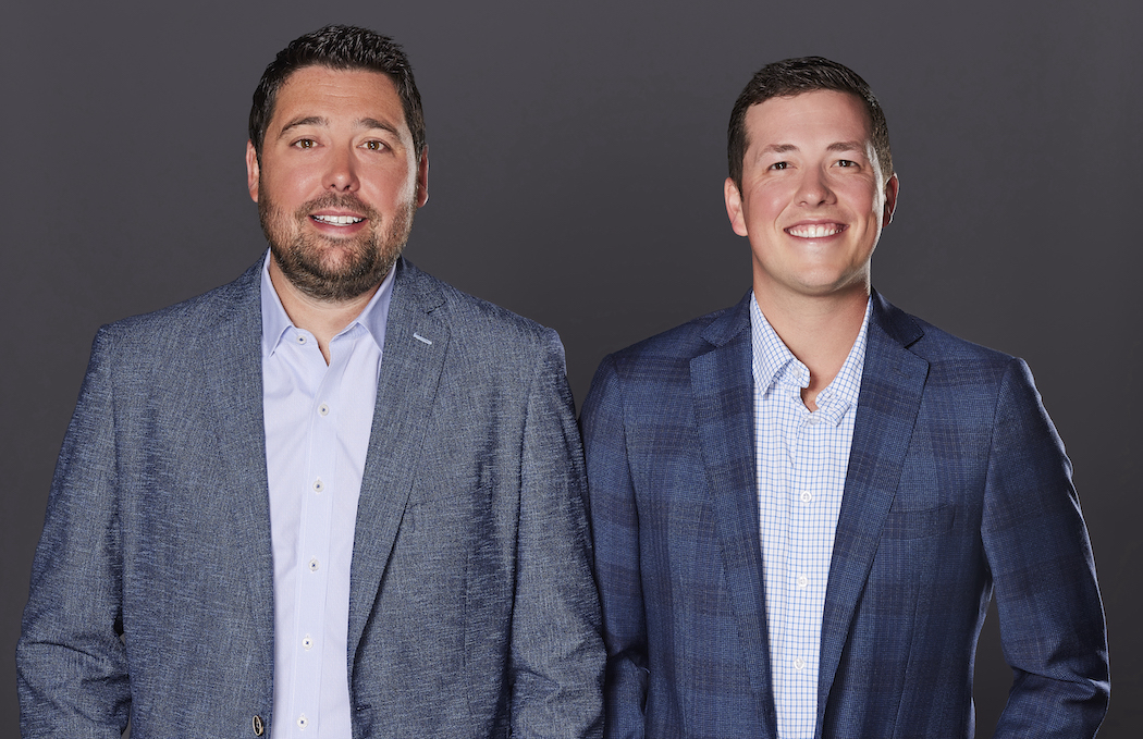 Two men in suits standing side by side.