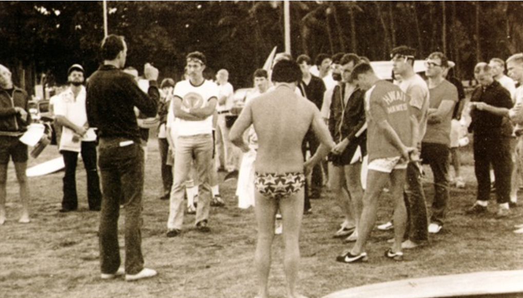 Photo: A group of people standing around, waiting to begin the first IRONMAN race.